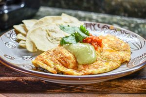 Vaječná omeleta s červenou salsou, avokádovou salsou a kukuřičnými tortilla chipsy